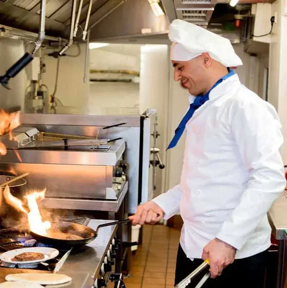 Parkrose Chateau Chef Created Meals, chef frying a dish.